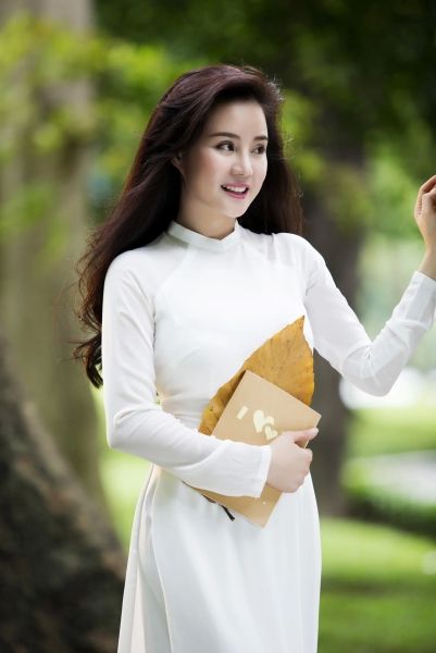 Cô gái xinh đẹp Ao Dai tạo ra một tạo dáng nhẹ nhàng