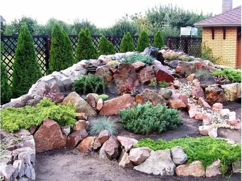 The beautiful natural rockery helps the garden space become more perfect.